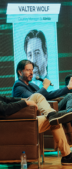 Palestrante em evento da Abria falando ao microfone